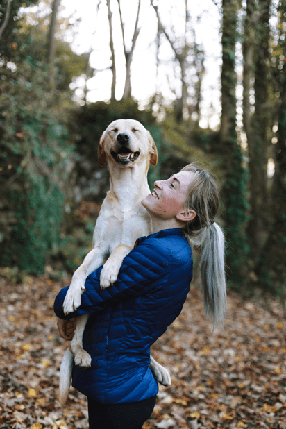 Woman with blue jacket hold her dog